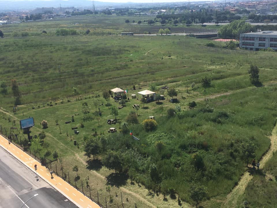 Veduta aerea del parco oggi: prato curato, alberi, gazebo e pista ciclabile